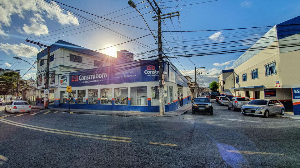 Fachada da loja Tavinho na esquina da Rod. Serafim Derenzi, com a placa TAVINHO na lateral e a faixa Rede Construbom na frente